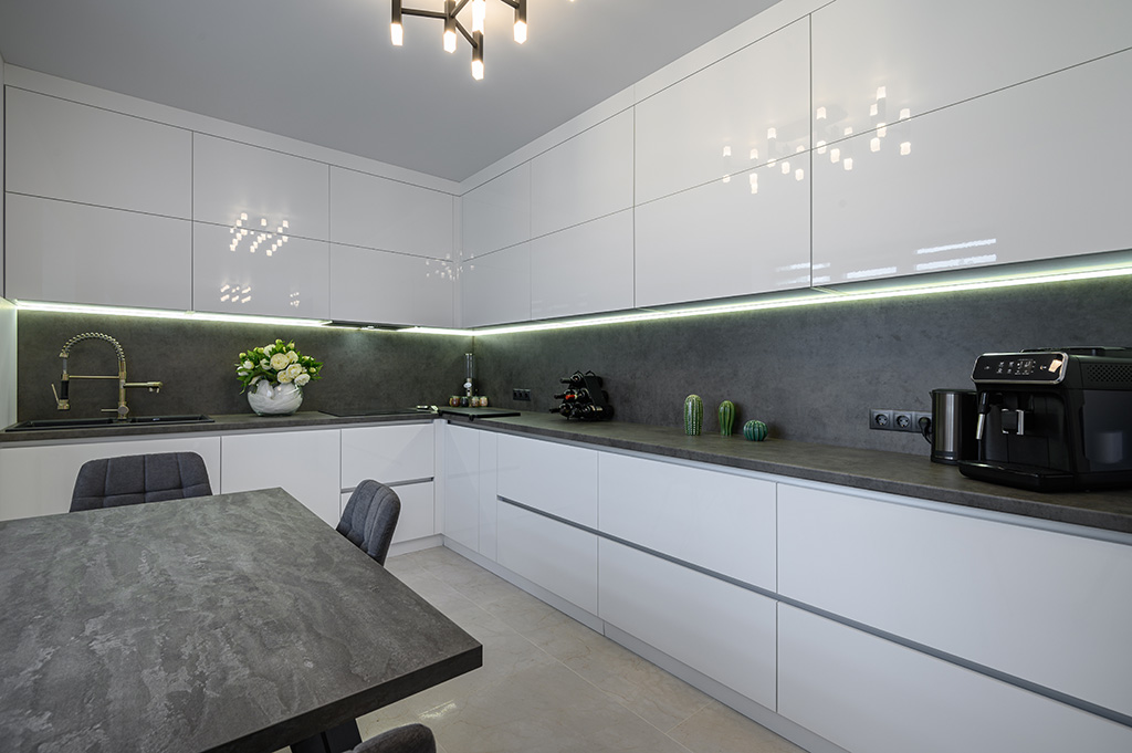 Luxurious modern trendy white and grey kitchen interior after renovation, with granite countertop